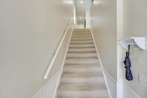 a staircase in a house with white walls and carpet at 4 Mi to Beaches St Simons Island Escape with Patio! in Ebo Landing