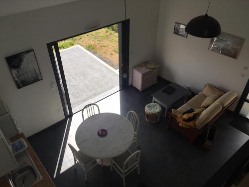 an overhead view of a living room with a table and chairs at Maisonnette climatisé avec terrasse et jardin in Sallertaine