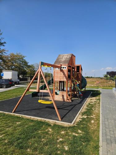 a swing set in front of a small house at Apartament Rasnov VMP Free parking in Râşnov
