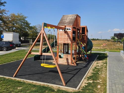 a play structure with a swing and a house at Studio Râșnov VMP Free Parking in Râşnov