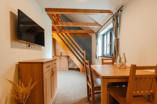 a dining room with a table and a television at Apartmány Na Salaši in Pec pod Sněžkou