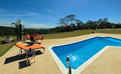 Cabanas do Rancho - Lazer & Eventos em São Roque في ساو روكي: مسبح بجانبه طاولة وكراسي