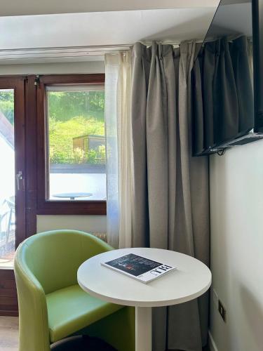 a room with a table and a chair and a window at Alchimia WellResort in Comano Terme