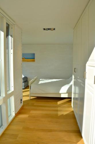 a bedroom with a bed and a wooden floor at Luxury summer house on Bolmsö in Bolmsö
