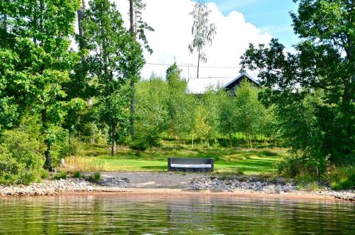 a bench sitting next to a body of water at Luxury summer house on Bolmsö in Bolmsö