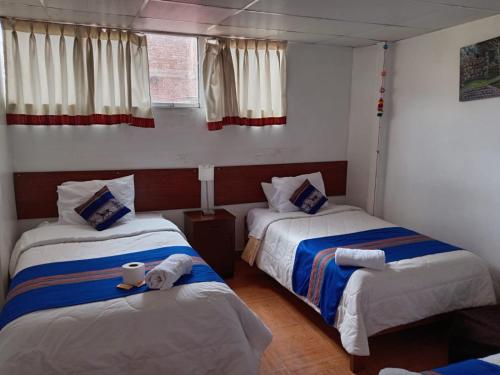 a bedroom with two beds with towels on them at Hosp Sophie in Cusco