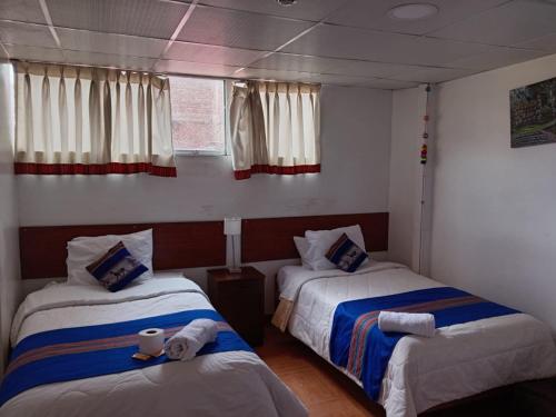 a bedroom with two beds and a window at Hosp Sophie in Cusco