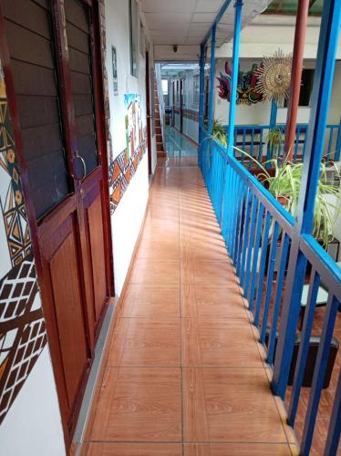 a hallway of a house with a wooden floor and blue railing at Hosp Sophie in Cusco