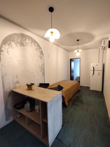 Camera con letto, tavolo e frigorifero. di Miatello a Villa Nueva