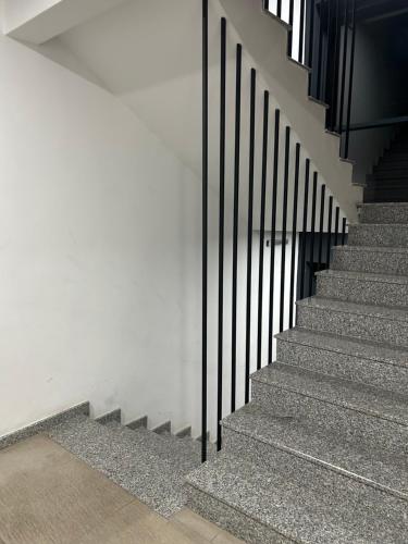 a staircase with black railings in a building at Mirror Apartments in Petrovec