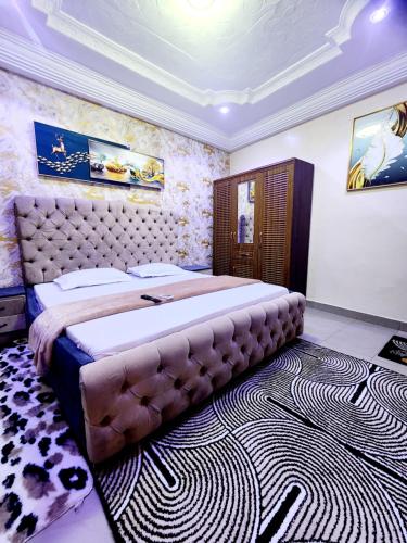 a bedroom with a large bed in a room with a rug at Mini Studio au rez de chaussée in Ouakam