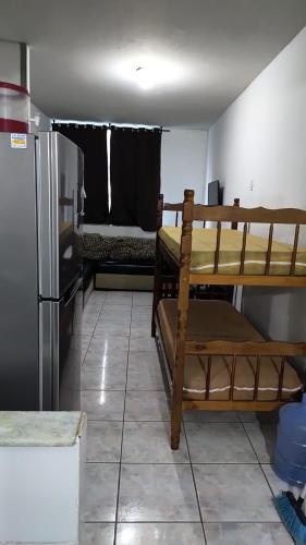 a room with two bunk beds and a refrigerator at Apartamento na Praia do Forte - Cabo Frio in Cabo Frio