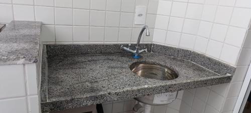 een vuile wasbak in een badkamer met een fossiel bij Ape Condomínio Club - pé na areia in Mongaguá