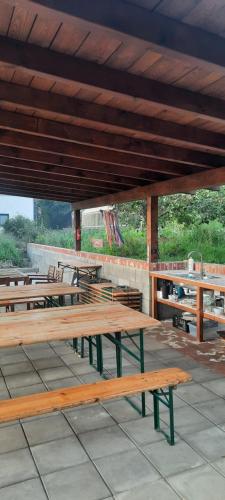 a group of wooden benches sitting under a roof at Pełen Wypas - Dziadówka in Przeworno