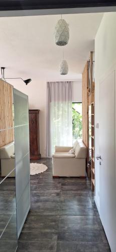 a living room with a couch and a window at Pełen Wypas - Dziadówka in Przeworno