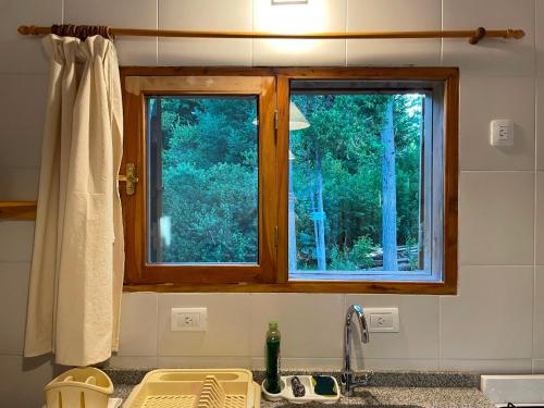 una cocina con una ventana sobre un fregadero y un fregadero en Ranel Bolsón, en El Bolsón