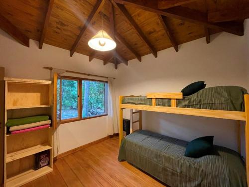 una habitación con dos literas y una ventana en Ranel Bolsón, en El Bolsón