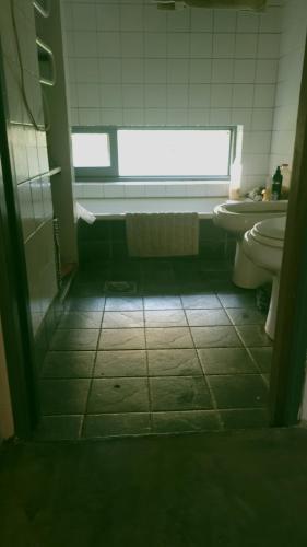 une salle de bain avec un lavabo et des toilettes et une fenêtre dans l'établissement Casadearte, à Arana