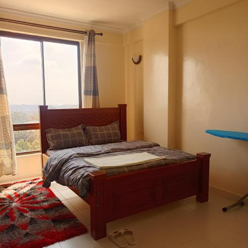 a bedroom with a bed and a large window at Ngong Home Stays in Ngong
