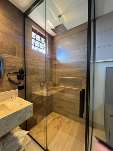 a shower with a glass door in a bathroom at Status Motel Ourinhos in Ourinhos