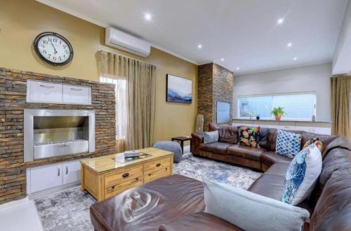 a living room with a couch and a fireplace at Pinnacle Golf Estate Haven in Mossel Bay
