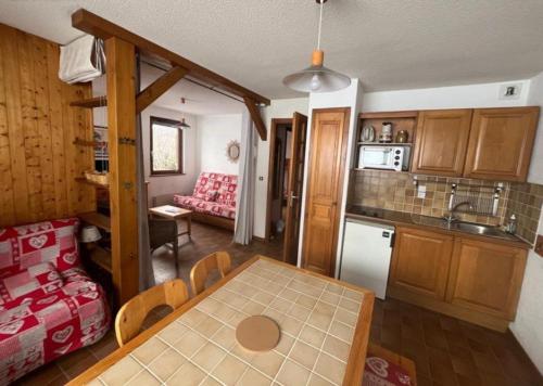 a kitchen and a dining room with a table at Location Appartement - Le grand Bornand Chinaillon - Pied des pistes in Le Chinaillon