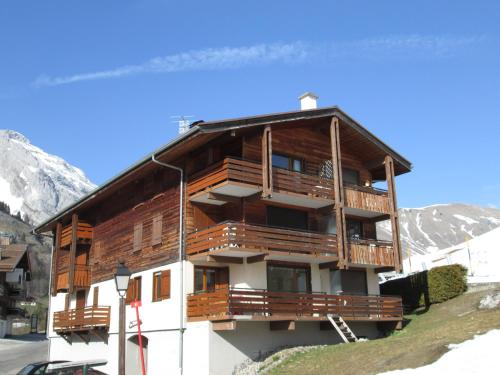 a large wooden building with a balcony on a mountain at Location Appartement - Le grand Bornand Chinaillon - Pied des pistes in Le Chinaillon