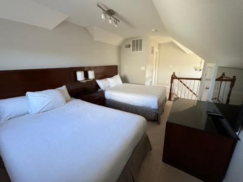 GlencarlynにあるGorgeous Spacious Home 5BR 9Beds with Private Parkingのベッド2台とテレビがあるホテルの部屋