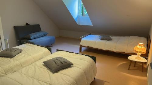 a room with two beds and a table with a lamp at Appartement au pied de la montagne in Guchen