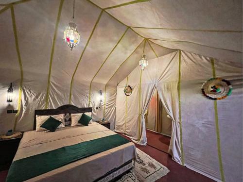 a bedroom with a bed in a tent at merzouga camping in Merzouga