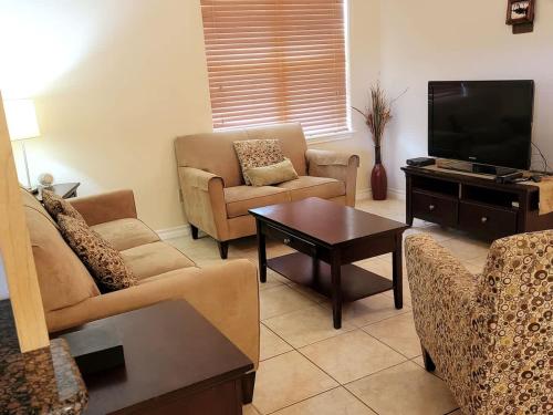 un soggiorno con divani e TV a schermo piatto di # Pet Friendly # Overlooks Pool Sleeps Tons a South Padre Island