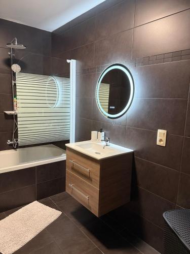 a bathroom with a sink and a tub and a mirror at Urban Cocoon in Liège