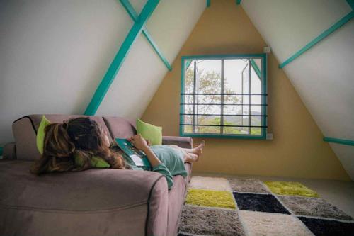 a girl laying on a couch reading a book at Shenaya Plantation 