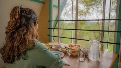 a woman sitting at a table with a plate of food at Shenaya Plantation 