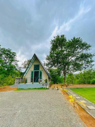 a small house on a gravel road with trees at Shenaya Plantation 