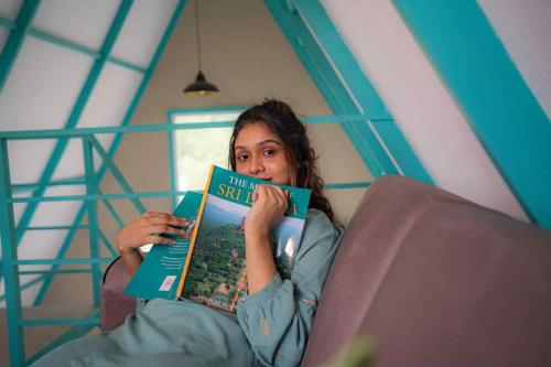 a woman sitting in a chair reading a book at Shenaya Plantation 