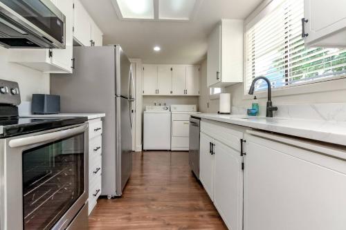 a kitchen with white cabinets and white appliances at Short Walk to DT/ AC/Gas Fire Pit/BBQ/Coffee Bar in Enumclaw