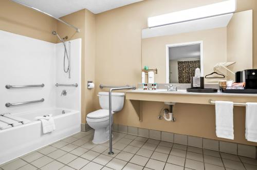a bathroom with a toilet and a tub and a sink at Americas Best Value Inn - Rome in Lindale