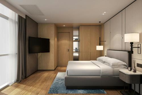 a bedroom with a bed and a flat screen tv at Sathorn Vista, Bangkok - Marriott Executive Apartments in Bangkok