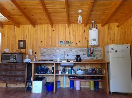 a kitchen with a sink and a refrigerator in a room at Los Alamos in Plottier