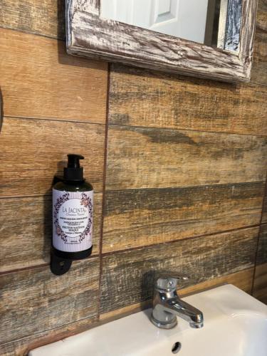 a soap bottle on a wall next to a sink at Cabañas Estacion del Lago in Puerto Varas