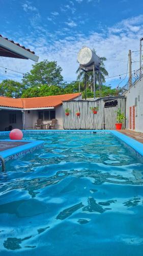 a swimming pool with blue water in front of a building at The Corner Hostel in Playa Blanca