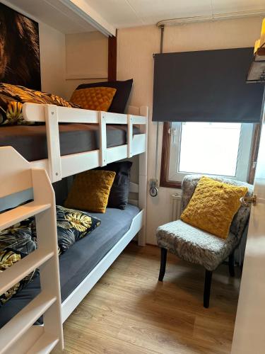 a bedroom with a bunk bed and a chair at Woonboot De Witte loosdrechtse plassen in Loosdrecht