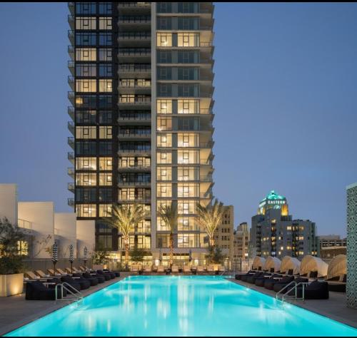 a swimming pool in front of a tall building at 2BR Panoramic City View!! in Los Angeles