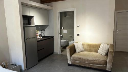 ein Wohnzimmer mit Couch und Küche in der Unterkunft Smartroom Lula di Correggio in Correggio