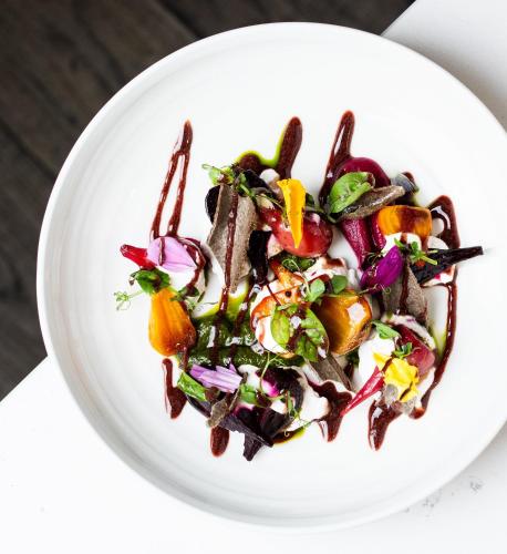 a bowl of salad on a white plate at Kimpton Hotel Monaco Washington DC by IHG in Washington
