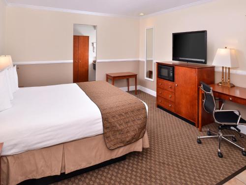 a hotel room with a bed and a flat screen tv at Best Western Capistrano Inn in San Juan Capistrano