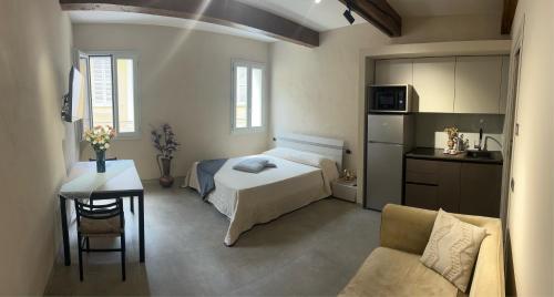 a bedroom with a bed and a table and a couch at Smartroom Lula di Correggio in Correggio