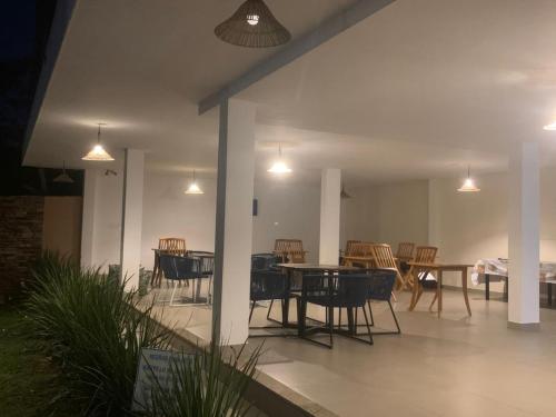 Un patio con mesa, sillas y luces. en Foca Guest House, en Búzios