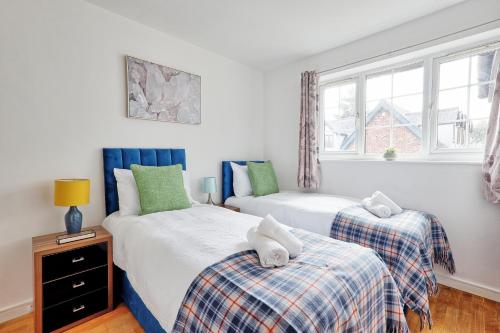 a bedroom with two beds and a window at Quirky 2-Bed Brentwood Home Near High St & Station - With Parking in Brentwood